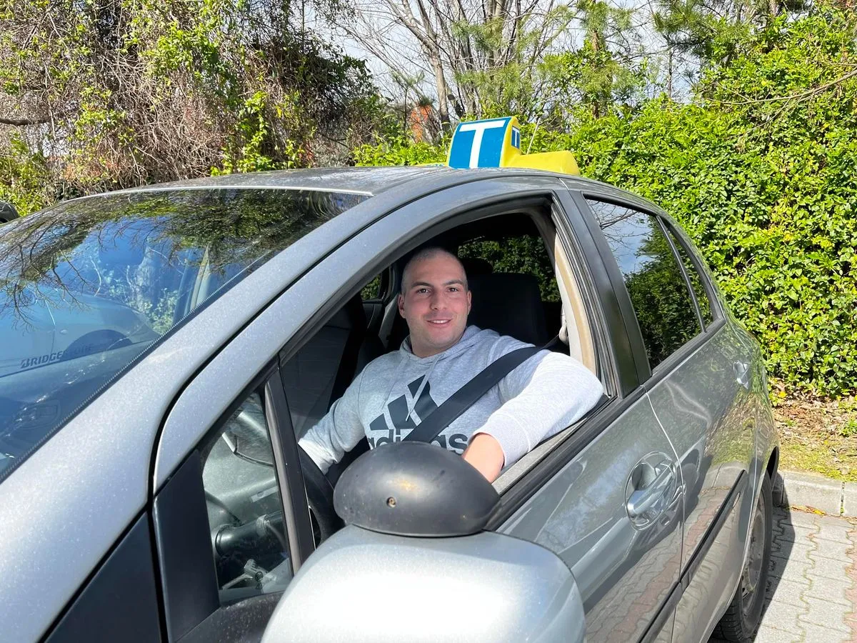 Réfi Ferenc, autós oktató az oktató autójával.